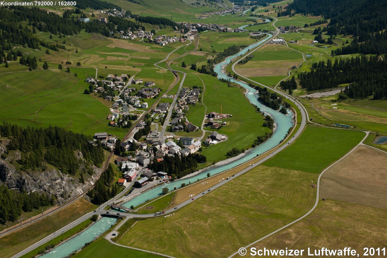 Dorf im Bildzentrum: Madulain (Position: 2'792'016.02, 1'162'868.62), nördlich davon, Bildmitte links: Spih, Dorf ganz oben Bildmitte: S-Chanf; davor Rchtg. W: Zuoz, dann: Chaunt da Crusch. - Inn (rätorom. En) fliesst von W nach E: Bildmitte im ersten Prallhang: aufgeweitete 'Aue Suotarivas', weiter ostwärts im zweiten Prallhang: 'Aue Batrumieu'.